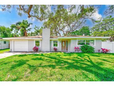 Charming home with a well-maintained lawn, flowers and a newer garage door at 3572 Pocahontas Dr, Largo, FL 33774