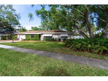 Charming single-story home with a well-manicured front yard and mature trees at 6801 5Th N St, St Petersburg, FL 33702