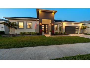 Beautiful home exterior with modern design elements, manicured lawn and garden, and a two-car garage at 8580 Ivy Stark Blvd, Wesley Chapel, FL 33545