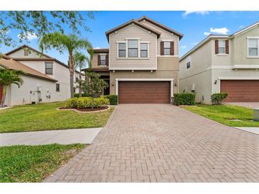 Charming two-story home featuring a brick driveway, attached garage and well-manicured lawn at 935 Terra Vista St, Brandon, FL 33511