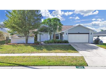 Charming single-story home featuring a well-manicured lawn and a two-car garage at 1472 Overland Dr, Spring Hill, FL 34608