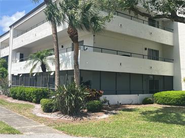 A three-story condo building with balconies, palm trees, and green landscaping with the windows looking out to a courtyard at 2583 Countryside Blvd # 3102, Clearwater, FL 33761