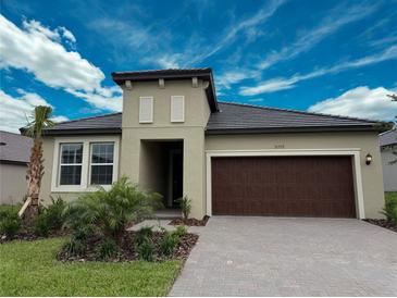 Charming single-story home featuring a two-car garage and landscaped front yard at 31753 Griffin Sands Ln, San Antonio, FL 33576
