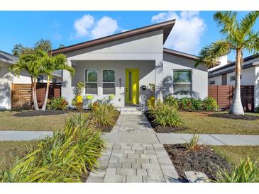 Charming single Gathering home with a well-manicured lawn, walkway, and a bright yellow front door at 511 45Th N Ave, St Petersburg, FL 33703