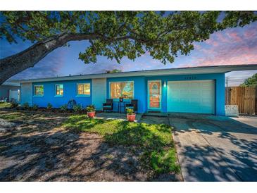 Charming single-story home with a well-maintained lawn and a vibrant blue exterior at 13970 Montego Dr, Seminole, FL 33776