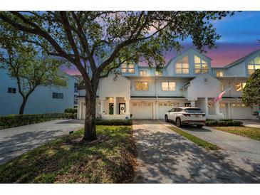 Charming townhome exterior featuring white siding, attached garage, and well-maintained landscaping at 14692 Seminole Trl, Seminole, FL 33776