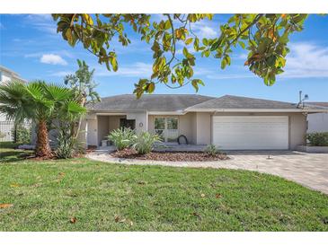 Charming single-story home with lush landscaping, paved driveway, and an attached two car garage at 3901 E Eden Roc Cir, Tampa, FL 33634