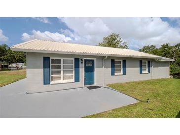 Charming single-story home featuring gray paint, blue shutters, and a light-colored metal roof at 4508 26Th S Ave, Tampa, FL 33619
