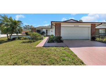 Charming single-story home with a well-maintained front lawn and colorful landscaping at 4534 Great Lakes S Dr, Clearwater, FL 33762