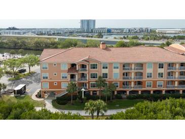 Multi-story condominium featuring a terracotta-tile roof, balconies, and picturesque waterfront views at 5000 Culbreath Key Way # 9-104, Tampa, FL 33611