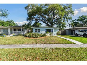 Charming single-story home with a well-manicured front yard and mature trees on a sunny day at 1821 20Th N Ave, St Petersburg, FL 33713