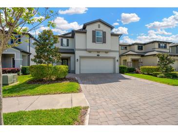 Beautiful two-story home featuring manicured landscaping and a brick paved driveway leading to a two car garage at 19592 Breynia Dr, Lutz, FL 33558