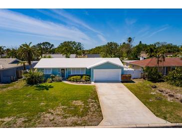 Charming single-story home with a well-maintained lawn and a long driveway leading to the garage at 2972 E Vina Del Mar Blvd, St Pete Beach, FL 33706