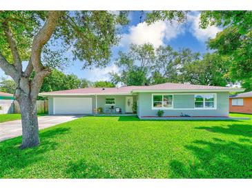 Charming single-story home featuring a well-manicured lawn and mature shade tree at 533 Keene Rd, Largo, FL 33771
