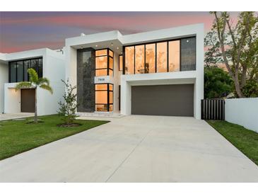 Modern two-story home boasting large windows, a grey two-car garage, and minimalist landscaping at 7608 Antilla St, Tampa, FL 33625