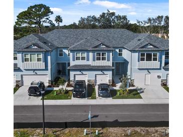 Charming townhomes featuring a blue exterior, attached garages, and well-maintained landscaping in a desirable community at 7765 93Rd N St, Seminole, FL 33777