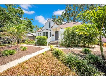 Charming two-story home with a beautifully landscaped front yard with green foliage and a stone pathway at 150 23Rd N Ave, St Petersburg, FL 33704