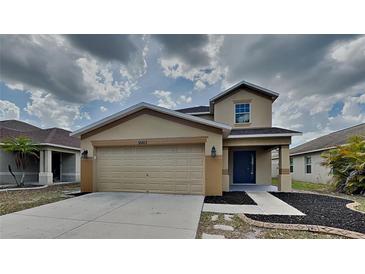 Charming two-story home with a two-car garage and neutral-toned facade at 15411 Quail Woods Pl, Ruskin, FL 33573