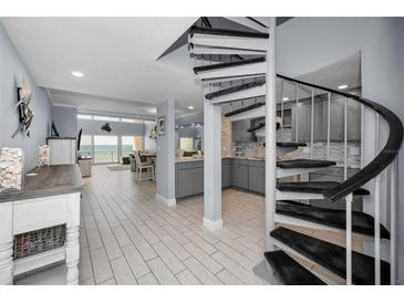 Open-concept entryway featuring spiral staircase, grey cabinetry, and views of the ocean at 19700 Gulf Blvd # 403, Indian Shores, FL 33785