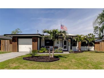 Charming single-story home featuring a well-manicured lawn, modern design, and an attached one car garage at 2488 Del Rio Way, Dunedin, FL 34698