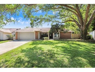 Charming single-story home with mature trees, manicured lawn, and a two-car garage at 2558 Arborwood Dr, Valrico, FL 33596