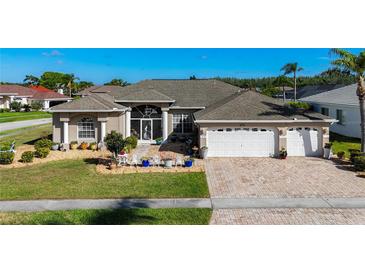 Charming home boasts a three-car garage and meticulously maintained front yard and walkway with lush landscaping at 3625 Gaviota Dr, Ruskin, FL 33573
