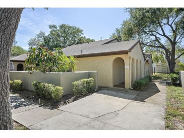Charming exterior view of home featuring an arched entry and landscaped walkway to the front door at 6262 142Nd N Ave # 1106, Clearwater, FL 33760