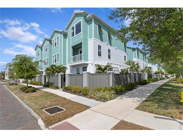 Charming townhomes with green and white exterior, landscaped yards, and sidewalk access on a sunny day at 98 29Th S St, St Petersburg, FL 33712