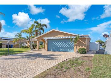 Charming home featuring a spacious blue garage door, neutral paint color, and a patterned brick drive at 1012 Spindle Palm Way, Apollo Beach, FL 33572
