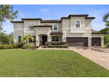Two-story home boasts a three-car garage, well-manicured lawn, and a charming neutral-tone exterior at 19810 Prince Benjamin Dr, Lutz, FL 33549