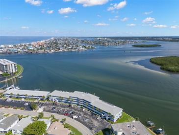Wide aerial view showcasing a waterfront condominium complex with stunning coastline and ocean views at 280 126Th Ave # 106, Treasure Island, FL 33706