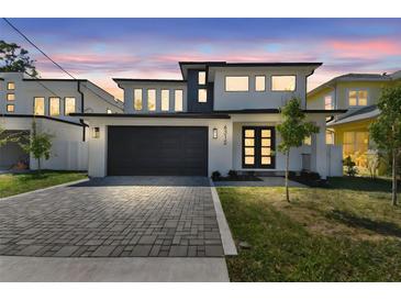 Modern two-story home boasts a dark garage door and a beautifully paved driveway at 6315 S Richard Ave, Tampa, FL 33616