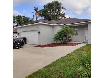Charming single-story home featuring a two-car garage, complemented by lush landscaping and mature trees at 6690 54Th N Ave, St Petersburg, FL 33709