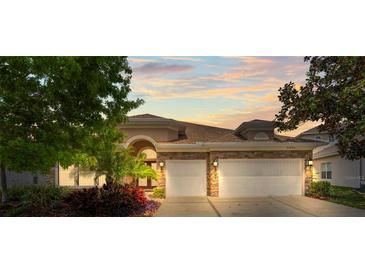 Charming home featuring a stone facade, well-manicured landscaping and an attached two-car garage at 11534 Biddeford Pl, New Port Richey, FL 34654