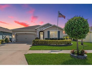 Charming single-story home features a well-manicured lawn, stone accents, and an attached two-car garage at 31649 Tansy Bnd, Wesley Chapel, FL 33545