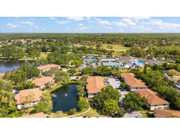 Overhead view of community including pool, tennis courts, manicured grounds, and complex buildings at 3380 Crystal Court E # G, Palm Harbor, FL 34685