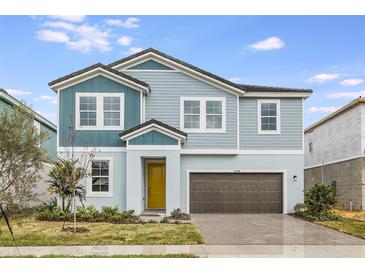 Charming two-story home features a yellow front door, brick driveway, and manicured landscaping at 10037 Surrey Rose Dr, San Antonio, FL 33576