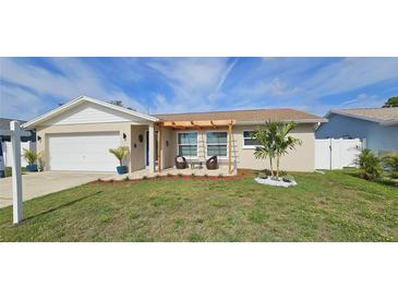 Charming single-story home features a well-maintained lawn, pergola, and a cozy seating area at 10884 118Th St, Seminole, FL 33778