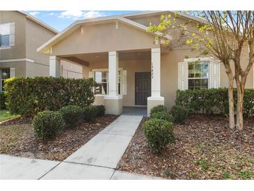 Charming home featuring a covered porch with classic columns and a neatly landscaped yard at 13423 Lake Monroe Pl, Riverview, FL 33579