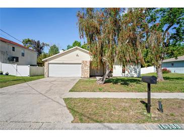 Charming single-story home with stone accents, well-maintained lawn, and attached two-car garage at 16139 Villa Dr, Hudson, FL 34667