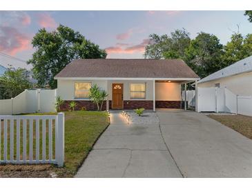 Charming single-story home with brick accents, a cozy carport, and lush landscaping at 439 E Boyer St, Tarpon Springs, FL 34689