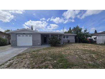 Charming single-story home with a well-maintained front yard and attached garage with stone veneer siding at 4750 Panorama Ave, Holiday, FL 34690