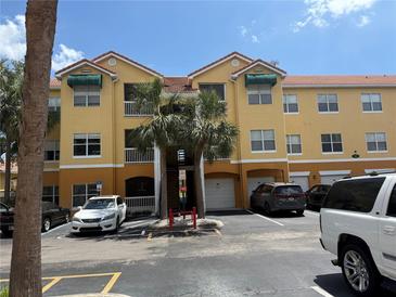 Attractive three-story condo building with a tile roof, green awnings, and palm trees at 10764 70Th Ave # 4302, Seminole, FL 33772