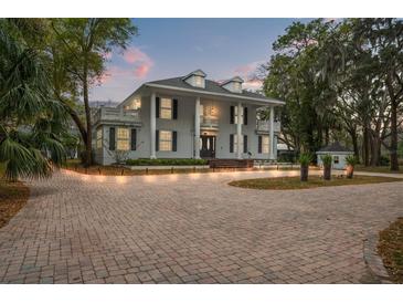 Stunning two-story home featuring a brick driveway, large columns, second floor balcony and a well-manicured front yard at 17062 Comunidad De Avila, Lutz, FL 33548