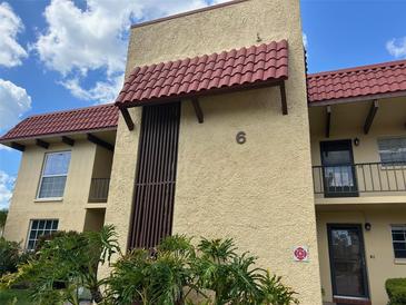 Exterior view of a well-maintained building with red roof and manicured shrubbery at 1845 S Highland Ave # 6-11, Largo, FL 33756