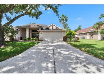 Charming single-story home with a well-maintained lawn and a long driveway leading to a two-car garage at 3505 Kilmer Dr, Plant City, FL 33566