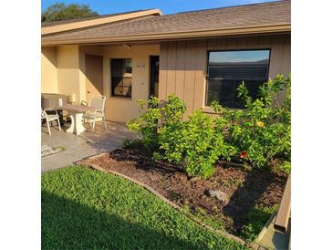 Charming home exterior featuring a small front yard with lush landscaping and a cozy seating area at 38243 Ironwood Pl, Zephyrhills, FL 33542
