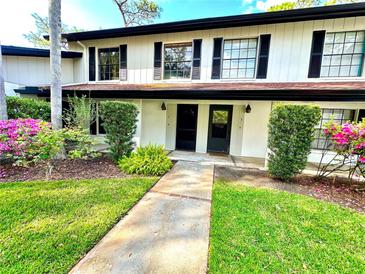 Charming townhouse entrance with landscaped garden and black shutters and doors at 5454 Saddlebrook Way # 2, Wesley Chapel, FL 33543