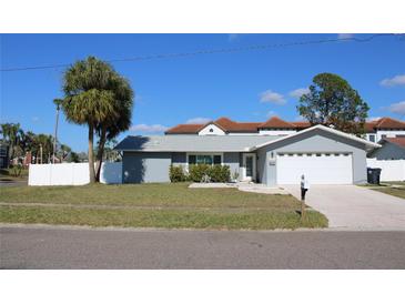 Charming single-story home featuring a well-manicured lawn, driveway, garage, and beautifully painted exterior at 6225 Imperial Ky, Tampa, FL 33615