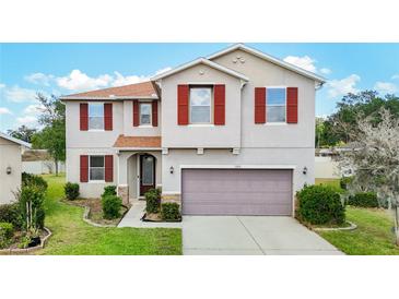 Charming two-story home with red shutters, a well-manicured lawn, and a two-car garage at 1105 Canyon Oaks Dr, Brandon, FL 33510